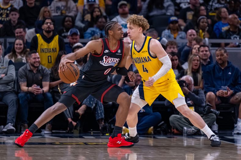 Tyrese Maxey, de los 76ers de Filadelfia, conduce el balón frente a Taelon Peter, de los Pacers de Indiana, en el duelo del viernes 10 de abril de 2026 (AP Foto/Doug McSchooler)