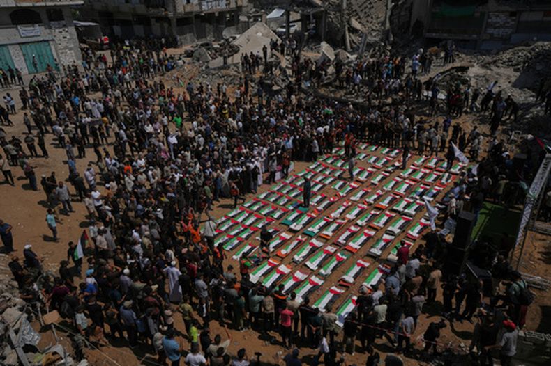 Los cuerpos de miembros de las familias Hassayna y Abu Sharia, muertos en un ataque israelí en 2023 y recientemente recuperados de los escombros, están cubiertos con banderas palestinas durante su funeral en Gaza, el martes 4 de agosto de 2026. (Foto AP/Jehad Alshrafi)