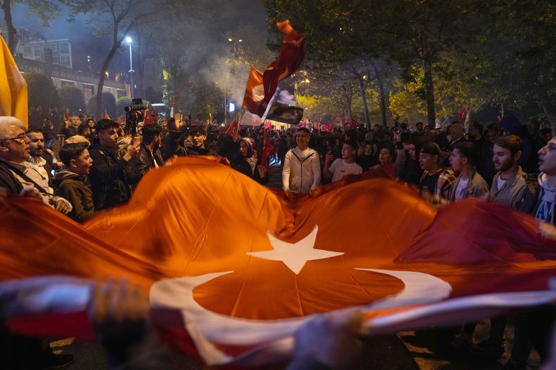 Partidarios del presidente de Turquía, Recep Tayyip Erdogan, celebran ante la sede del Partido Justicia y Desarrollo en Estambul, Turquía, el domingo 14 de mayo de 2023. Las elecciones presidenciales de Turquía parecían encaminarse el lunes hacia una segunda vuelta. El presidente, Recep Tayyip Erdogan, que ha gobernado el país con firmeza durante 20 años, consiguió más votos que su principal rival, pero no suficientes para una victoria directa. (AP Foto/Khalil Hamra)