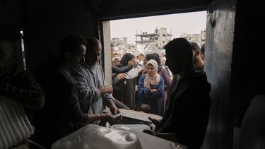Palestinos reciben ayuda humanitaria distribuida por UNRWA, la agencia de la ONU que ayuda a los refugiados palestinos en Jabaliya, Franja de Gaza, el miércoles 9 de abril de 2025. (AP Foto/Jehad Alshrafi)