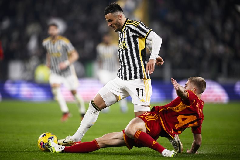 Filip Kostic de la Juventus pelea por el balón con Rasmus Kristensen de la Roma en el encuentro de la Serie A el sábado 30 de diciembre del 2023. (Fabio Ferrari/LaPresse via AP)
