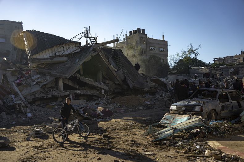 Palestinos buscan cadáveres y sobrevivientes entre los escombros de un edificio residencial destruido en un ataque aéreo de Israel, en Rafah, en el sur de la Franja de Gaza, el 15 de diciembre de 2023. (AP Foto/Fatima Shbair)