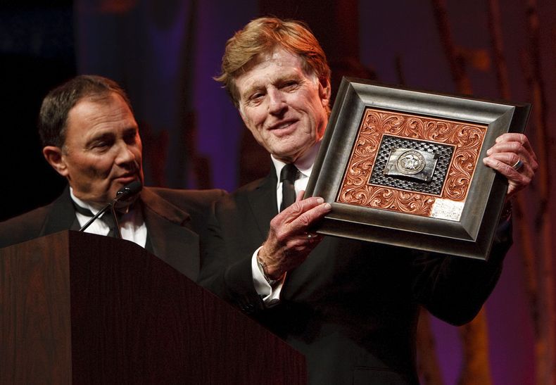 El gobernador Gary Herbert (izquierda) entrega a Robert Redford un presente por todas sus contribuciones al estado de Utah, el s&aacute;bado 9 de noviembre de 2013. (Foto AP/The Salt Lake Tribune, Leah Hogsten)