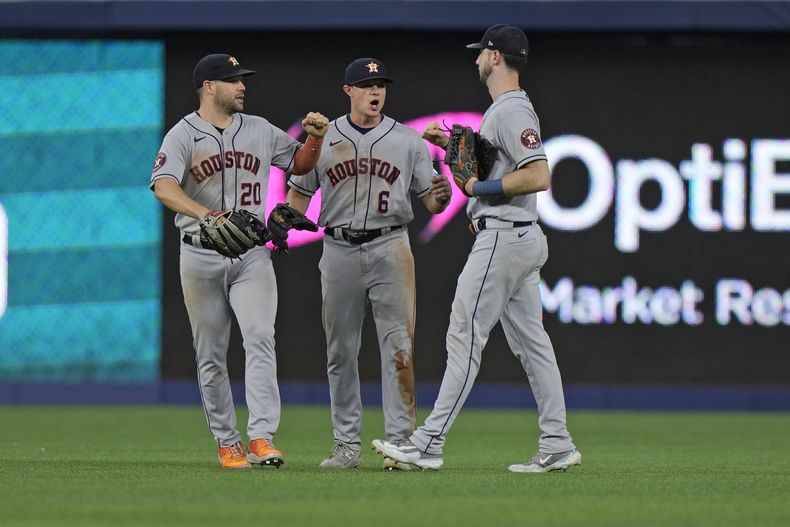 Chas McCormick (20), jardinero izquierdo de los Astros, festeja con sus compañeros Jake Meyers (6) y Kyle Tucker, tras la victoria sobre los Marlins de Miami, el martes 15 de agosto de 2023 (AP Foto/Wilfredo Lee)