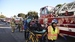 Una mujer es trasladada en una camilla cerca del sitio donde un avión se estrelló, el jueves 2 de enero de 2025, en Fullerton, California. (AP Foto/Kyusung Gong)