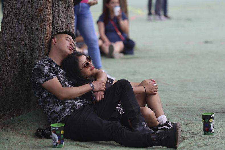 ARCHIVO - Una pareja descansa durante el Festival Vive Latino en la Ciudad de México el 17 de marzo de 2024. (Foto AP/Ginnette Riquelme, archivo)