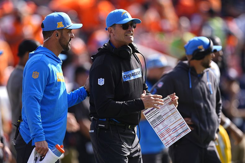 Jim Harbaugh, centro, head coach de los Chargers de Los Ángeles, regresó a la banda de su equipo después de ser atendido por personal médico. Aquí sigue con la mirada las acciones del partido de la NFL en contra de los Broncos de Denver, el domingo 13 de octubre de 2024, en Denver. (AP Foto/David Zalubowski)
