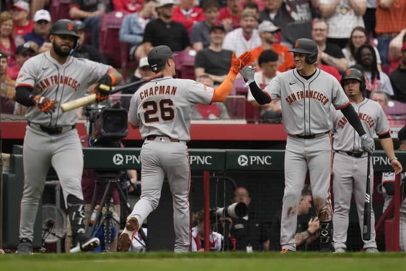 Matt Chapman (26), de los Gigantes de San Francisco, celebra después de batear un cuadrangular de dos carreras con Wilmer Flores, segundo desde la derecha, durante la sexta entrada del juego de béisbol de las mayores frente a los Rojos de Cincinnati, el domingo 30 de marzo de 2025, en Cincinnati. (AP Foto/Carolyn Kaster)