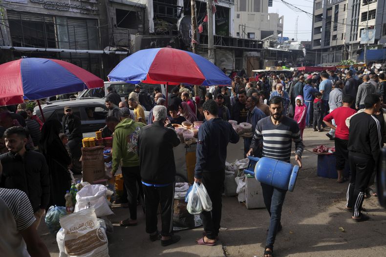 Palestinos visitan un mercado al aire libre en el campo de refugiados de Nusseirat, en la Franja de Gaza, el sábado 25 de noviembre de 2023, en el segundo día de un cese del fuego entre Hamás e Israel. (AP Foto/Adel Hana)