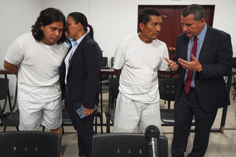 Alejandro Henríquez, a la izquierda, y José Ángel Pérez, segundo por la derecha, hablan con sus abogados antes de su primera audiencia judicial en Santa Tecla, El Salvador, el viernes 30 de mayo de 2025. La policía los detuvo por protestar frente a la residencia presidencial. (AP Foto/Salvador Meléndez)