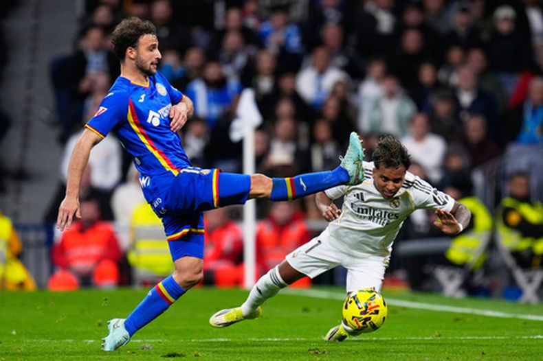 Rodrygo (derecha) del Real Madrid pugna por el balón con Sebastián Boselli de Getafe en el partido de la Liga española, el lunes 2 de marzo de 2026. (AP Foto/Manu Fernández)