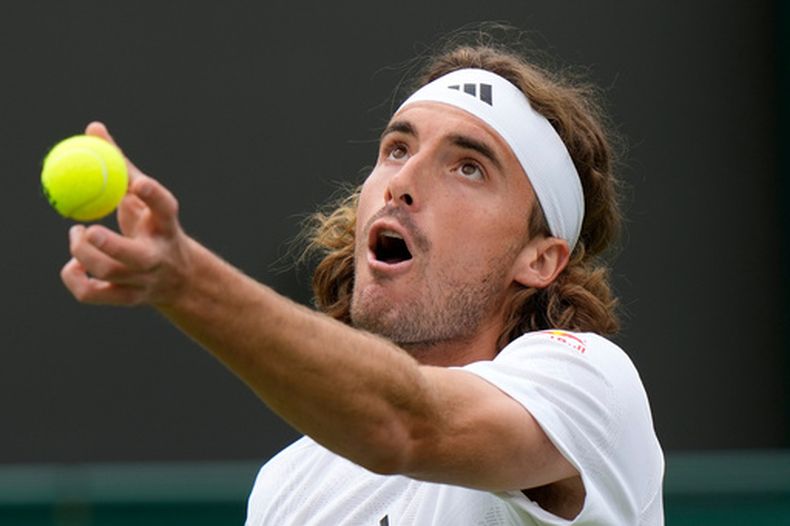 El griego Stefanos Tsitsipas saca ante el austriaco Dominic Thiem en la primera ronda del torneo individual de Wimbledon el martes 4 de julio del 2023. (AP Foto/Alastair Grant)