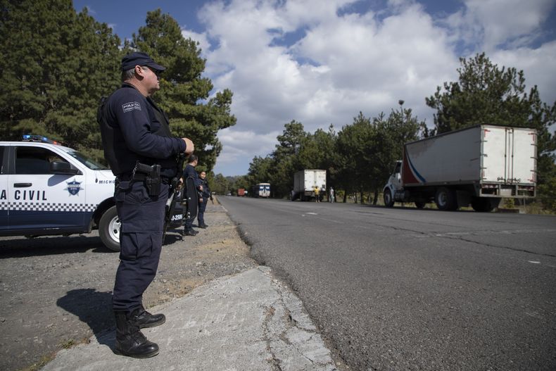 Policías resguardan un camión cargado con aguacates que se dirige a la ciudad de Uruapan, el 26 de enero de 2023, en Santa Ana Zirosto, en el estado de Michoacán, México. (AP Foto/Armando Solis, Archivo)
