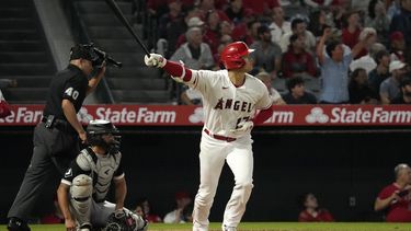 Shohei Ohtani de los Angelinos de Los Ángeles avanza a primera tras conectar un jonrón frente al cátcher de los Medias Blancas de Chicago Yasmani Grandal y el umpire Roberto Ortiz en la séptima entrada del juego del martes 27 de junio del 2023. (AP Foto/Mark J. Terrill)