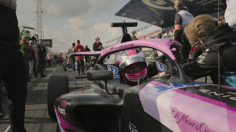 En esta foto proporcionada por Netflix, la actriz Abbi Pulling aparece en un auto en la serie F1: The Academy. (Netflix vía AP)