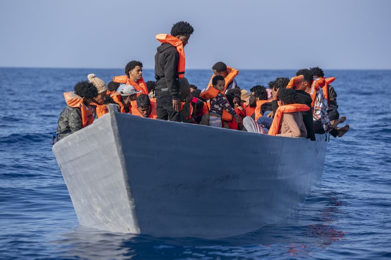 Migrantes de Eritrea, Libia, y Sudán a bordo de una embarcación de madera mientras esperan recibir ayuda por parte de trabajadores de una organización sin fines de lucro de España, en el mar Mediterráneo, el sábado 17 de junio de 2023. (AP Foto/Joan Mateu Parra)
