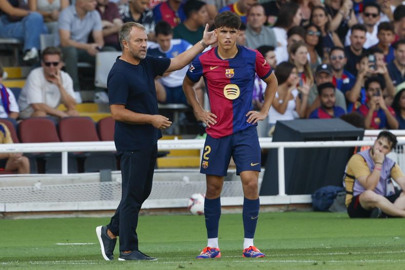 El técnico del Barcelona Hansi Flick le da instrucciones a Pau Cubarsí durante el encuentro de la liga española ante el Valladolid el sábado 31 de agosto del 2024. (AP Foto/Joan Monfort)