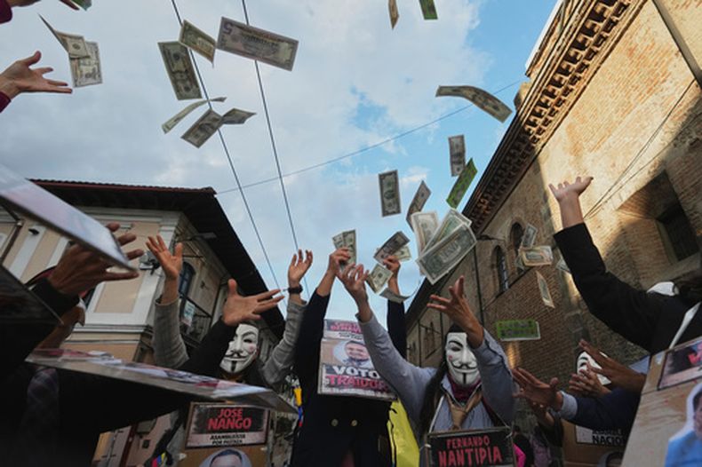 Manifestantes lanzan billetes falsos de dólar al aire durante una protesta antigubernamental en Quito, Ecuador, el viernes 13 de marzo de 2026. (Foto AP/Dolores Ochoa)