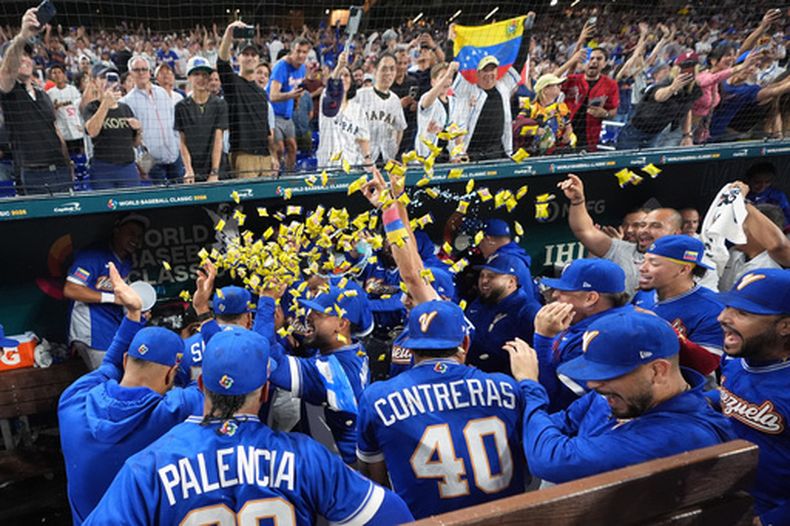 Los peloteros de Venezuela festejan en la cueva su victoria sobre Japón en el Clásico Mundial de béisbol, el sábado 14 de marzo de 2026 (AP Foto/Lynne Sladky)
