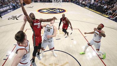 Jimmy Butler (22) del Heat de Miami Christian Braun de los Nuggets de Denver pugnan por un balón en el quinto de las Finales de la NBA, el lunes 12 de junio de 2023, en Denver. (Matthew Stockman/Pool Foto vía AP)