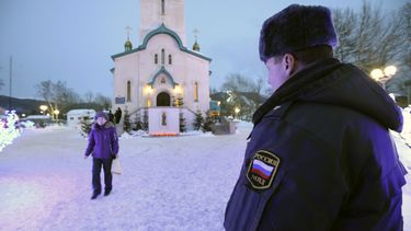americateve | Un polic&iacute;a vigila mientras una persona se retira de la Catedral de la Resurrecci&oacute;n de Cristo en la ciudad rusa de Yuzhno-Sajalinsk, en la isla de Sajalin, el domingo 9 de febrero de 2014, donde un individuo armado con un fusil mato a dos per