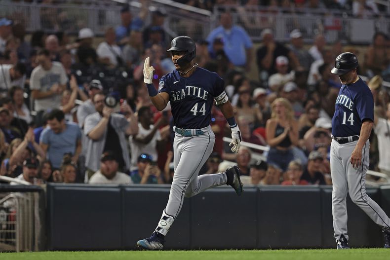 Julio Rodríguez (44) de los Marineros de Seattle avanza hacia el plato celebrando luego de conectar un cuadrangular en el octavo episodio del juego ante los Mellizos de Minnesota en Mineápolis. Martes 25 de julio de 2023.(AP Foto/Stacy Bengs)