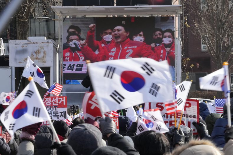Una pantalla de televisión muestra una imagen de archivo del presidente de Corea del Sur, Yoon Suk Yeol, durante una marcha de partidarios del impugnado presidente para oponerse a su destitución cerca de la residencia presidencial en Seúl, Corea del Sur, el martes 7 de enero de 2025. (AP Foto/Ahn Young-joon)