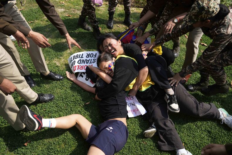 Policías intentan detener a exiliados tibetanos durante una protesta ante la embajada china por el aniversario del alzamiento de 1959 en Tíbet contra el gobierno chino, en Nueva Delhi, India, el lunes 10 de marzo de 2025. (AP Foto/Manish Swarup)