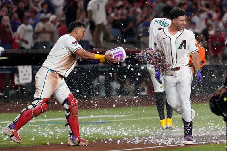 El venezolano Gabriel Moreno, de los Diamondbacks de Arizona, arroja goma de mascar a su compañero Ryan Waldschmidt, quien conectó el jonrón del triunfo ante los Cachorros de Chicago, el martes 25 de agosto de 2026 (AP Foto/Ross D. Franklin)