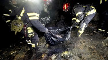 Rescatistas reúnen los restos de una persona que murió en un ataque ruso en un vecindario residencial en Járkiv, Ucrania, el sábado 29 de marzo de 2025. (AP Foto/Andrii Marienko)