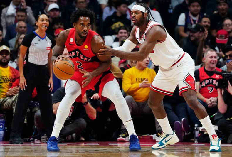 Kawhi Leonard (2), de los Raptors de Toronto, protege el balón de Buddy Hield (7), de los Bulls de Chicago, durante la primera mitad del partido de baloncesto de la NBA, el miércoles 21 de octubre de 2026. (Frank Gunn/The Canadian Press via AP)