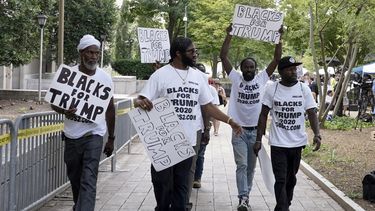 ARCHIVO - Simpatizantes del expresidente Donald Trump con carteles y camisetas en las que se lee «Negros por Trump» se reúnen cerca de la Corte Federal de Estados Unidos E. Barrett Prettyman, el 3 de agosto de 2023, en Washington. (AP Foto/Mariam Zuhaib, Archivo)