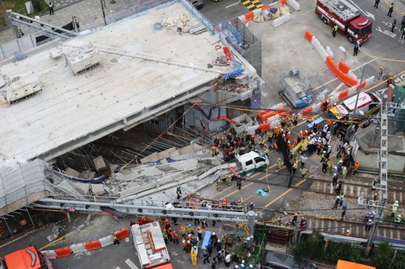 Bomberos y rescatistas surcoreanos tratan de buscar entre los escombros después de que un paso elevado se derrumbara parcialmente cuando se estaba desmontando en Seúl, Corea del Sur, el martes 26 de mayo de 2026. (Choi Jae-gu/Yonhap via AP)