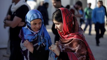 americateve | Malala Yousafzai, derecha, habla con Mzoun Mlihan, de 16 a&ntilde;os y refugiada siria, durante su visita al campamento de refugiados de Zaatari cerca de la frontera con Siria, en Mafraq, Jordania, el martes 18 de febrero del 2014. (Foto AP/Mohammad Hanno
