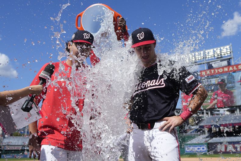 El abridor de los Nacionales de Washington Andrew Alvarez y el catcher CJ Stubbs son bañados por Josh Bells tras la victoria ante los Marlins de Miami el lunes primero de septiembre del 2025. (AP Foto/Jess Rapfogel)