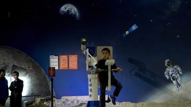 americateve | Un ni&ntilde;o juega con un aparato para caminatas espaciales en el Museo de Ciencia y Tecnolog&iacute;a de China en Beijing. El s&aacute;bado 14 de diciembre de 2013 China coloc&oacute; un veh&iacute;culo motorizado en la superficie de la Luna, la primer