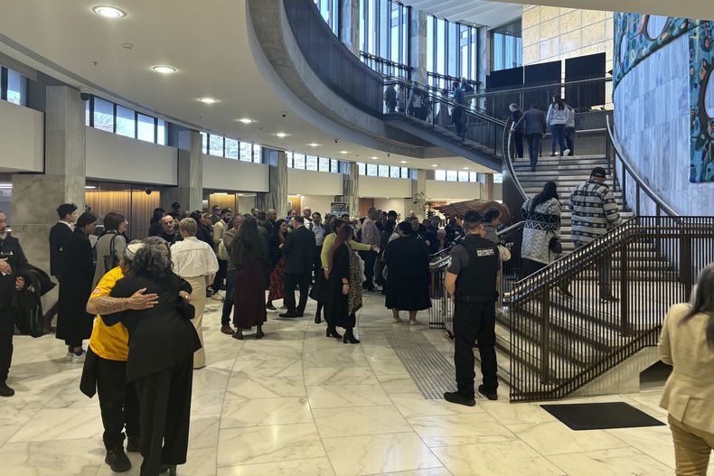 La gente llega al Parlamento en Wellington, Nueva Zelanda, el miércoles 24 de julio de 2024, para la presentación de una amplia investigación independiente sobre el abuso de niños y adultos vulnerables bajo la tutela del Estado, hechos que ocurrieron en el lapso de cinco décadas. (Foto AP/Charlotte Graham-McLay)