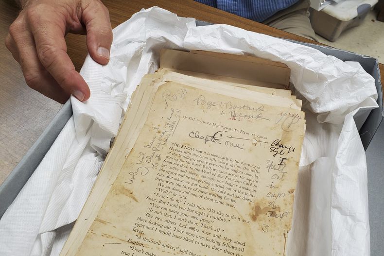 El historiador Corey Malcom muestra un primer borrador de la novela de Ernest Hemingway de 1937, To Have and Have Not (Tener y no tener), con notas manuscritas de Hemingway en los márgenes en el Centro de Historia de los Cayos de Florida en Key West, Florida, el lunes 15 de julio de 2024. (Foto AP/David Fischer)
