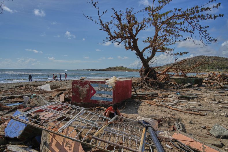 Algunas personas caminan por la orilla en Boca de dos Ríos, Cuba, el jueves 30 de octubre de 2025, después del paso del huracán Melissa. (AP Foto/Ramón Espinosa)