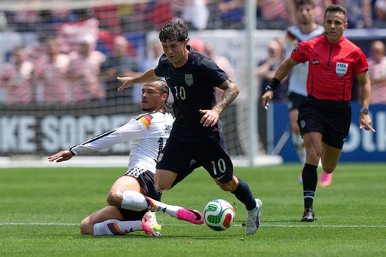 El atacante estadounidense Christian Pulisic (derecha) es derribado por el atacante alemán Leroy Sané durante un partido de las eliminatorias del Mundial, el sábado 6 de junio de 2026, en Chicago. (AP Foto/Nam Y. Huh)