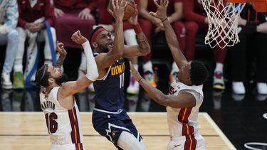 El alero de los Nuggets de Denver Bruce Brown avanza hacia la canasta mientras lo defienden el alero Caleb Martin y el base Kyle Lowry del Heat de Miami en el juego 4 de las Finales de la NBA el viernes 9 de junio del 2023. (AP Foto/Lynne Sladky)