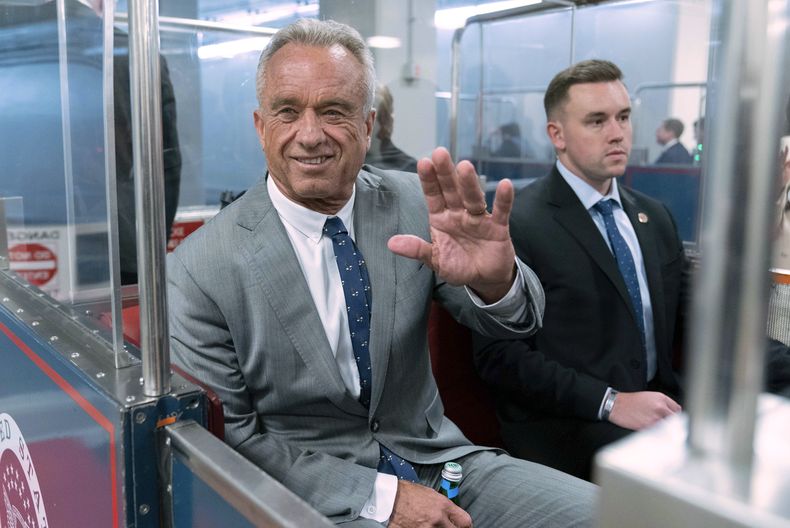 ARCHIVO - Robert F. Kennedy Jr. saluda a reporteros mientras toma el tren para reunirse con el senador John Thune en el Capitolio, en Washington, el 17 de diciembre de 2024. (AP Foto/Jose Luis Magana, Archivo)