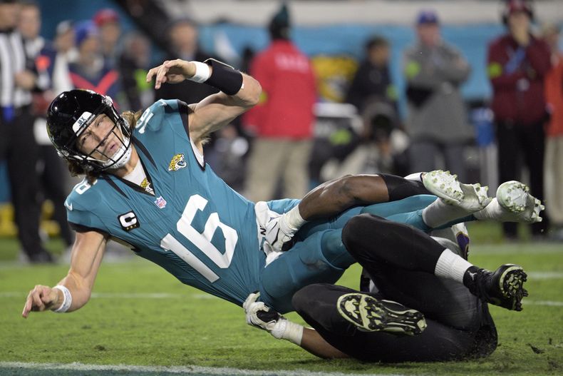Trevor Lawrence (16), quarterback de los Jaguars de Jacksonville, es derribado por Justin Madubuike, tackle defensivo de los Ravens de Baltimore, después de un pase lanzado por Lawrence durante la segunda mitad del juego de la NFL, el domingo 17 de diciembre de 2023, en Jacksonville, Florida. (AP Foto/Phelan M. Ebenhack)