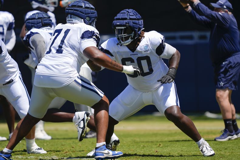 El tackle ofensivo de los Cowboys de Dallas, Tyler Guyton, a la derecha, y el guardia Chuma Edoga realizan ejercicios durante el campamento de entrenamiento de fútbol americano de la NFL, el martes 30 de julio de 2024, en Oxnard, California (AP Foto/Ryan Sun)