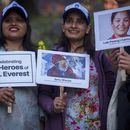 Tres mujeres sostienen carteles y fotos en homenaje a montañeros con récords, en los actos por el 70mo aniversario del primer ascenso a la cima del Everest en Katmandú, Nepal, el lunes 29 de mayo de 2023. (AP Foto/Niranjan Shrestha)