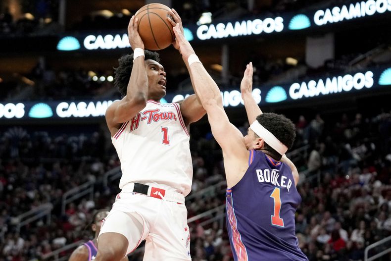 Amen Thompson, izquierda, de los Rockers de Houston, dispara mientras que Devin Booker, de los Suns de Phoenix, defiende durante la segunda mitad del juego de baloncesto de la NBA, el viernes 23 de febrero de 2024, en Houston. (AP Foto/Eric Christian Smith)