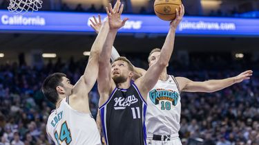 El pívot de los Kings de Sacramento Domantas Sabonis salta para tirar el balón de bandeja frente al pívot de los Grizzlies de Memphis Zach dey en el encuentro del lunes 17 de marzo del 2025. (AP Foto/Sara Nevis)