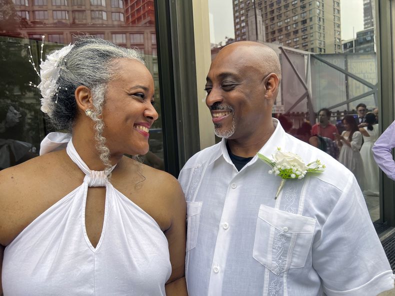 Hazel Seivwright-Carney y su esposo, Rohan Carney, sonríen en el Centro Lincoln de Nueva York, donde la pareja renovó sus votos nupciales durante una boda multitudinaria, el sábado 8 de julio de 2023. La pareja vivía junta desde hace 28 años. (AP Foto/Bobby Caina Calvan)