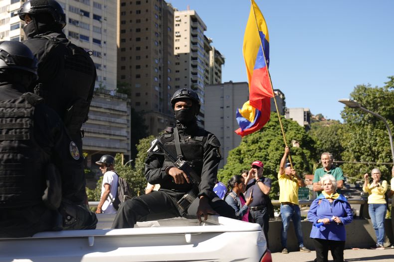 Las fuerzas de seguridad patrullan junto a los opositores del presidente venezolano Nicolás Maduro que se manifiestan el día antes de su toma de posesión para un tercer mandato en Caracas, Venezuela, el jueves 9 de enero de 2025. (AP Foto/Ariana Cubillos)