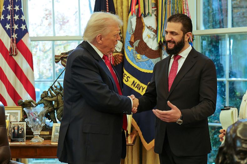 ARCHIVO - En esta imagen publicada por la oficina de prensa de la presidencia siria, el presidente de Estados Unidos, Donald Trump, a la izquierda, estrecha la mano del presidente de Siria, Ahmad al-Sharaa, en la Casa Blanca en Washington, el lunes 10 de noviembre de 2025. (Oficina de prensa de la presidencia siria via AP, Archivo)